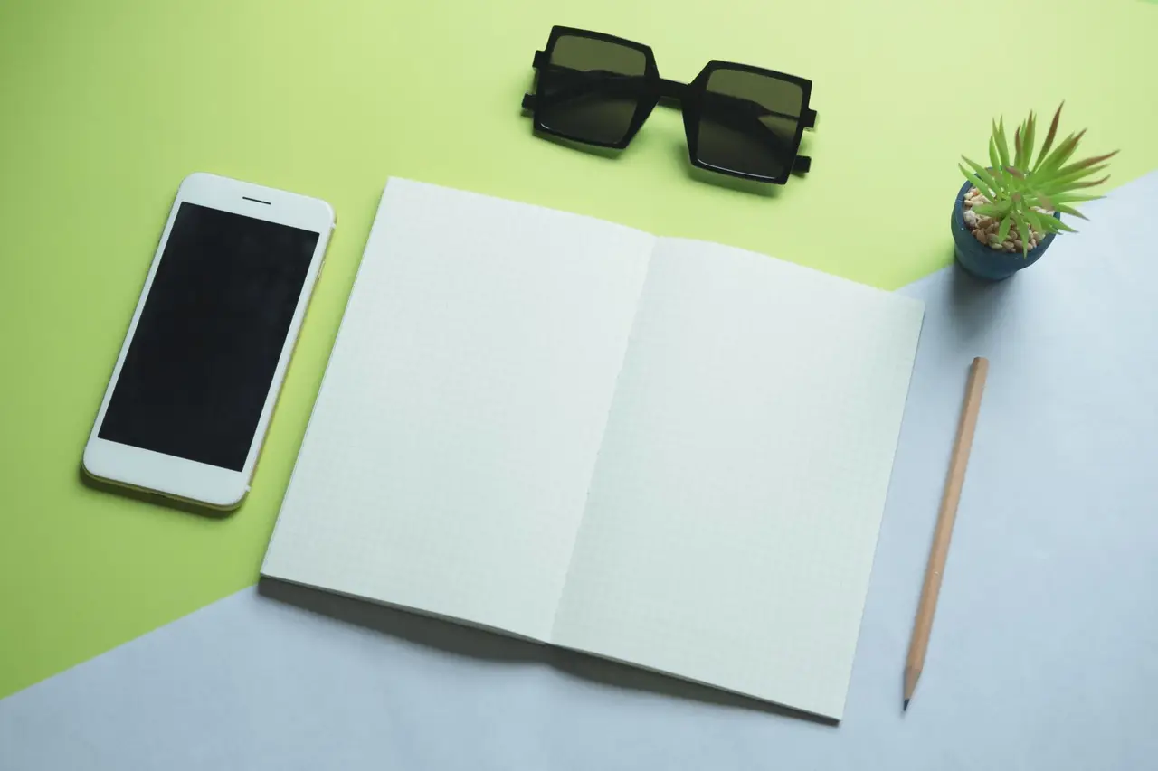 A phone and notebook on a desk